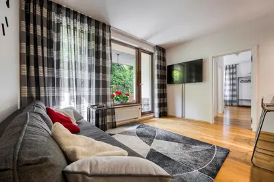 a living room with a couch and a television at Apartment with garden in Prague 6 in Prague