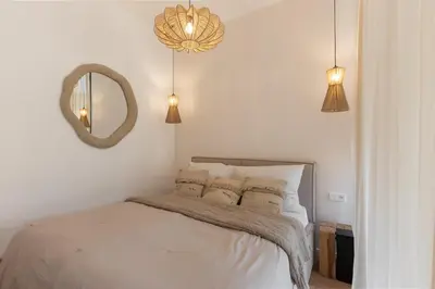 a white bedroom with a bed and a mirror at Dock by STING Hotels in Prague