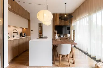 a kitchen with a white island and wooden cabinets at Dock by STING Hotels in Prague