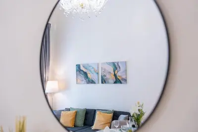 a mirror in a living room with a blue couch at Crystal Apartment in Center of Prague in Prague
