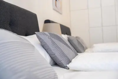 a white bed with white pillows on it at Crystal Apartment in Center of Prague in Prague