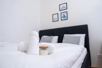 a white bed with a cup of coffee on it at Crystal Apartment in Center of Prague in Prague