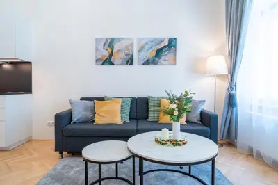 a living room with a blue couch and two tables at Crystal Apartment in Center of Prague in Prague