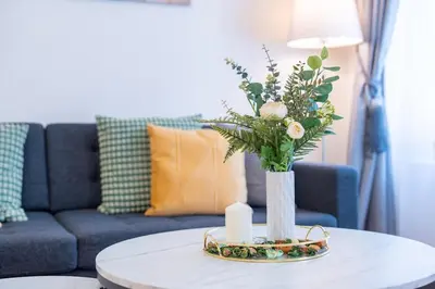 a table with a vase with flowers and candles on it at Crystal Apartment in Center of Prague in Prague