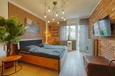 a bedroom with a bed and a brick wall at Modern Industry Studio in Prague