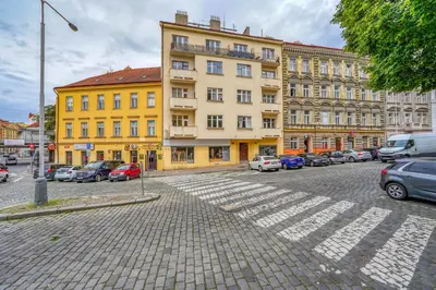a yellow building with cars parked in a parking lot at Modern Industry Studio in Prague