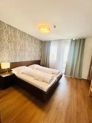 a bedroom with a large bed in a room with wooden floors at Villa many separate rooms with Free Parking Praha 4 libuš in Prague