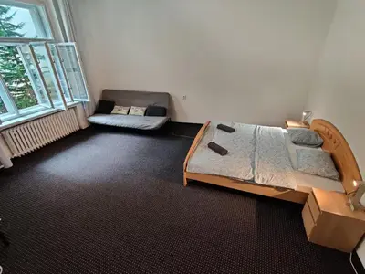 a bedroom with a large bed and a couch in it at Private Room With Free Parking Next to Railway Station in Prague