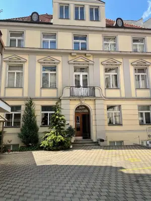 a large building with a door and a christmas tree in front at Private Room With Free Parking Next to Railway Station in Prague