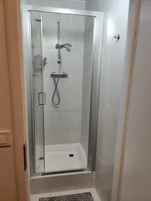 a shower with a glass door in a bathroom at Private Room With Free Parking Next to Railway Station in Prague