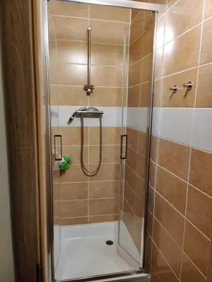 a shower with a glass door in a bathroom at Private Room With Free Parking Next to Railway Station in Prague