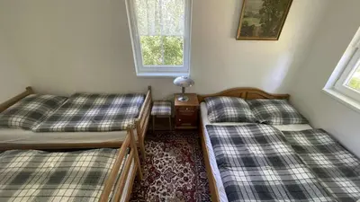 a bedroom with two beds and a window and a table at Chata Družec in Družec