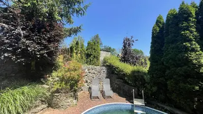 a swimming pool in a garden with chairs and trees at Chata Družec in Družec