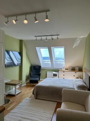 a bedroom with a bed and a chair and windows at Pistachio Apartment National Museum View in Prague