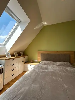 a attic bedroom with a bed and a window at Pistachio Apartment National Museum View in Prague