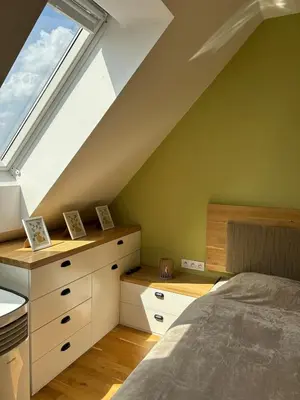 a attic bedroom with a bed and a window at Pistachio Apartment National Museum View in Prague
