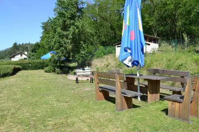 a picnic table with an umbrella and two benches at Župky in Županovice