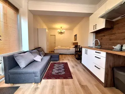 a living room with a couch and a kitchen at Terrace Suite - KindStay Suites Prague Airport in Tuchoměřice