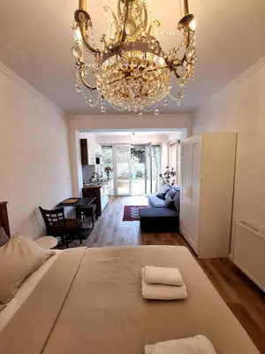 a bedroom with a large bed and a chandelier at Terrace Suite - KindStay Suites Prague Airport in Tuchoměřice