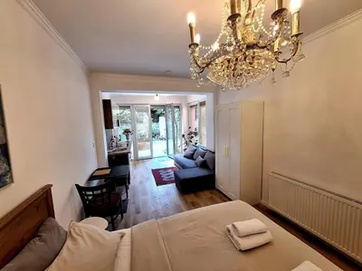 a bedroom with a bed and a chandelier at Terrace Suite - KindStay Suites Prague Airport in Tuchoměřice