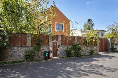 a brick house with a fence and a gate at Terrace Suite - KindStay Suites Prague Airport in Tuchoměřice