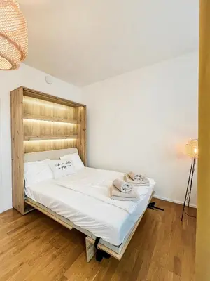 a bed with a wooden headboard in a room at The Urban Nest Metro Line in Prague