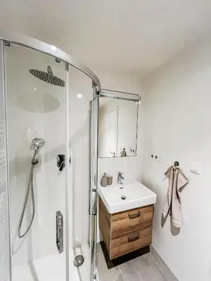 a white bathroom with a shower and a sink at The Urban Nest Metro Line in Prague