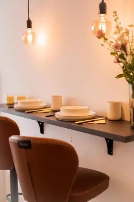 a dining room table with chairs and plates and lights at The Urban Nest Metro Line in Prague