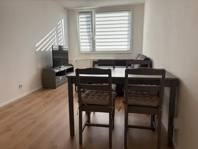 a dining room table with two chairs and a window at Čenětická Apartment in Prague