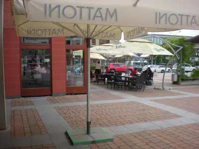 a patio with tables and umbrellas in front of a restaurant at Sophia Cozy Self Catering Apartment in Dolní Břežany