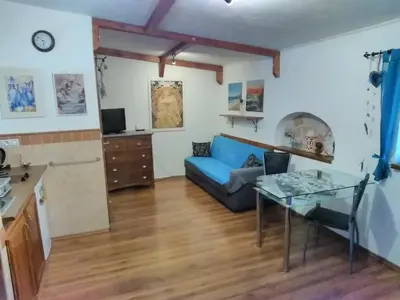 a living room with a blue couch and a glass table at Sophia Cozy Self Catering Apartment in Dolní Břežany