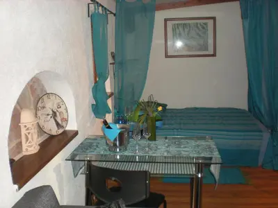 a bedroom with a bed and a table with a clock at Sophia Cozy Self Catering Apartment in Dolní Břežany
