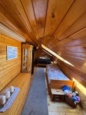a large room with a bed in a wooden cabin at Luxusní chalupa Kokořínsko
