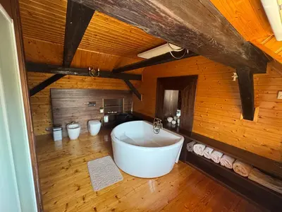 a large bath tub in a room with wooden walls at Luxusní chalupa Kokořínsko