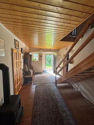 a living room with a wooden ceiling and a staircase at Luxusní chalupa Kokořínsko