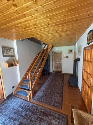 a staircase in a living room with a wooden ceiling at Luxusní chalupa Kokořínsko