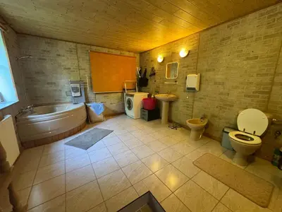 a bathroom with a tub and a toilet and a sink at Luxusní chalupa Kokořínsko