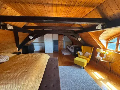 a large room with a bed and a couch and a chair at Luxusní chalupa Kokořínsko