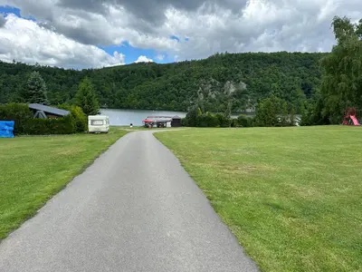 a road leading into a field with a lake at Solo tábořiště, kemp u vody, Nová Živohošť in Křečovice