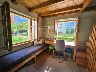 a room with a bed and a desk and a window at Bijou house in a private garden! in Prague