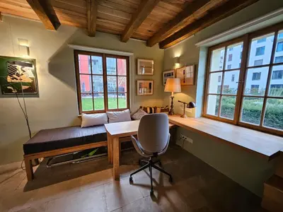 a room with a desk and a chair and windows at Bijou house in a private garden! in Prague