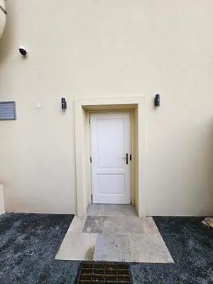 a white door in the side of a building at Bijou house in a private garden! in Prague