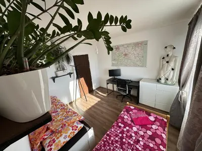 a living room with a potted plant and a desk at Jungle style 2 lockable bedrooms, 10 mins to center, top floor balcony with Prague view, king-size bed, high speed Internet, coffee in Prague