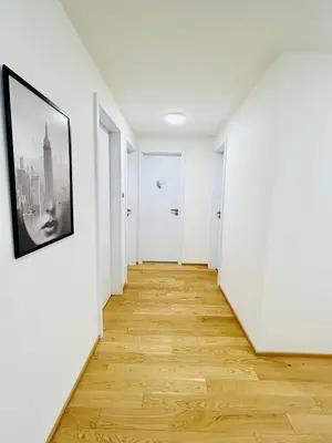 an empty hallway with white walls and wooden floors at Luxury apartments with beautiful views in Prague