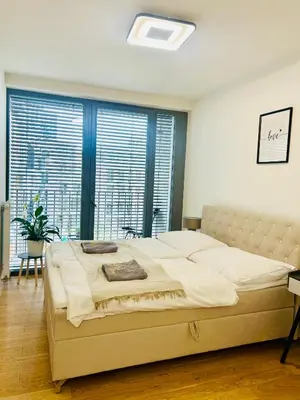 a bedroom with a large bed and a large window at Luxury apartments with beautiful views in Prague