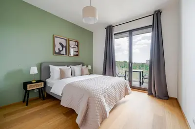 a bedroom with a bed and a large window at Blueground Prague 9 balcony free parking PRG-46 in Prague