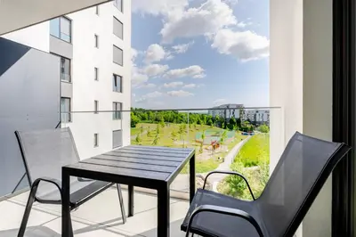 a table and chairs on a balcony with a view at Blueground Prague 9 balcony free parking PRG-46 in Prague