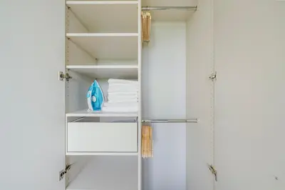 a closet with white cabinets and white towels at Blueground Prague 9 balcony free parking PRG-46 in Prague