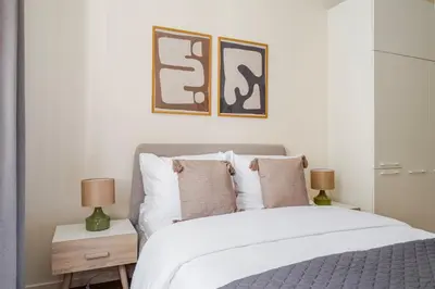 a bedroom with a bed with two lamps and two pictures on the wall at Blueground Letná furnished studio foodie area PRG-49 in Prague