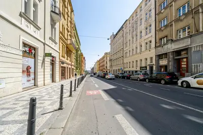 an empty city street with parked cars and buildings at Blueground Letná furnished studio foodie area PRG-49 in Prague